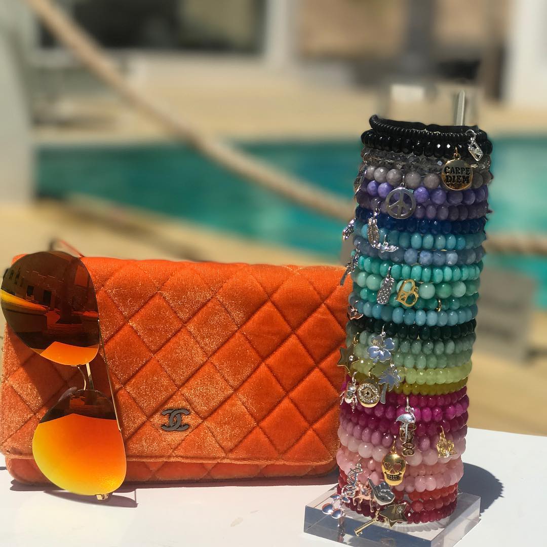 Clear vertical acrylic bracelet display stand with custom engraved logo for retail jewelry storage.