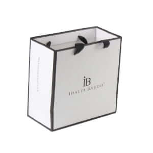 White art paper custom jewelry bags with logo, black border design, and black ribbon handles for luxury retail