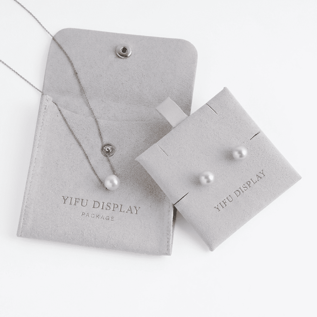microfiber jewelry pouch with button closure and custom gold foil logo for necklace and earring packaging.