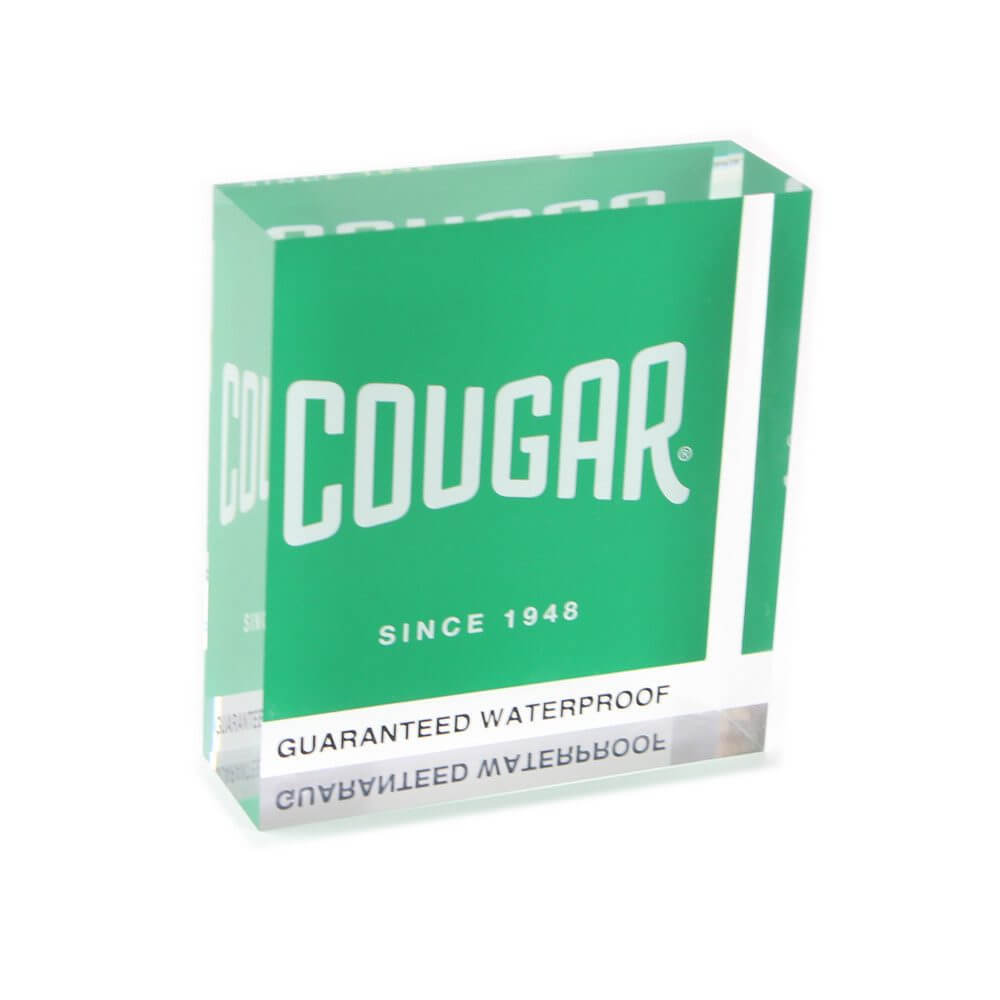 Custom paperweights made of 1.5-inch thick clear acrylic with a reverse-printed white logo on a green background.