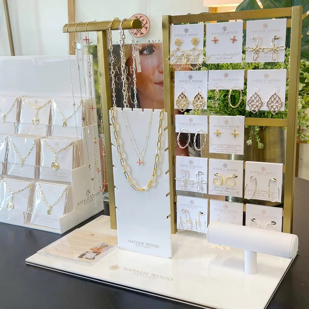 Luxury gold jewelry display set in white acrylic featuring gold-trimmed edges for high-end necklace and earring branding.