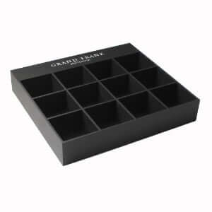 Matte black acrylic 12-slot jewelry display box with customizable logo inserts for rings and watches.
