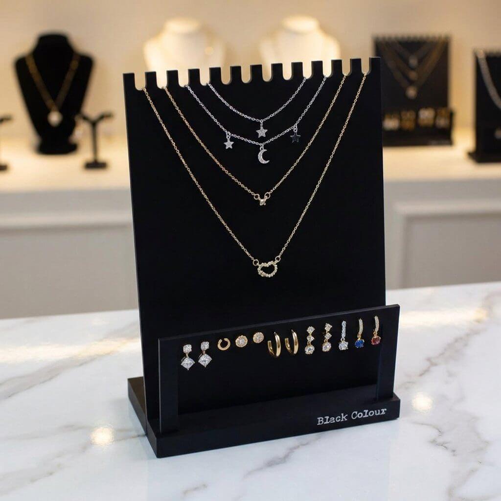 Black acrylic multi necklace display stand with 12 slots for showcasing 6 necklace sets and 6 pairs of earrings.