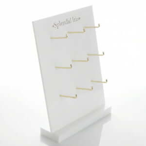 White acrylic leaning jewelry display stand with 9 gold hooks for hanging earring cards and necklaces