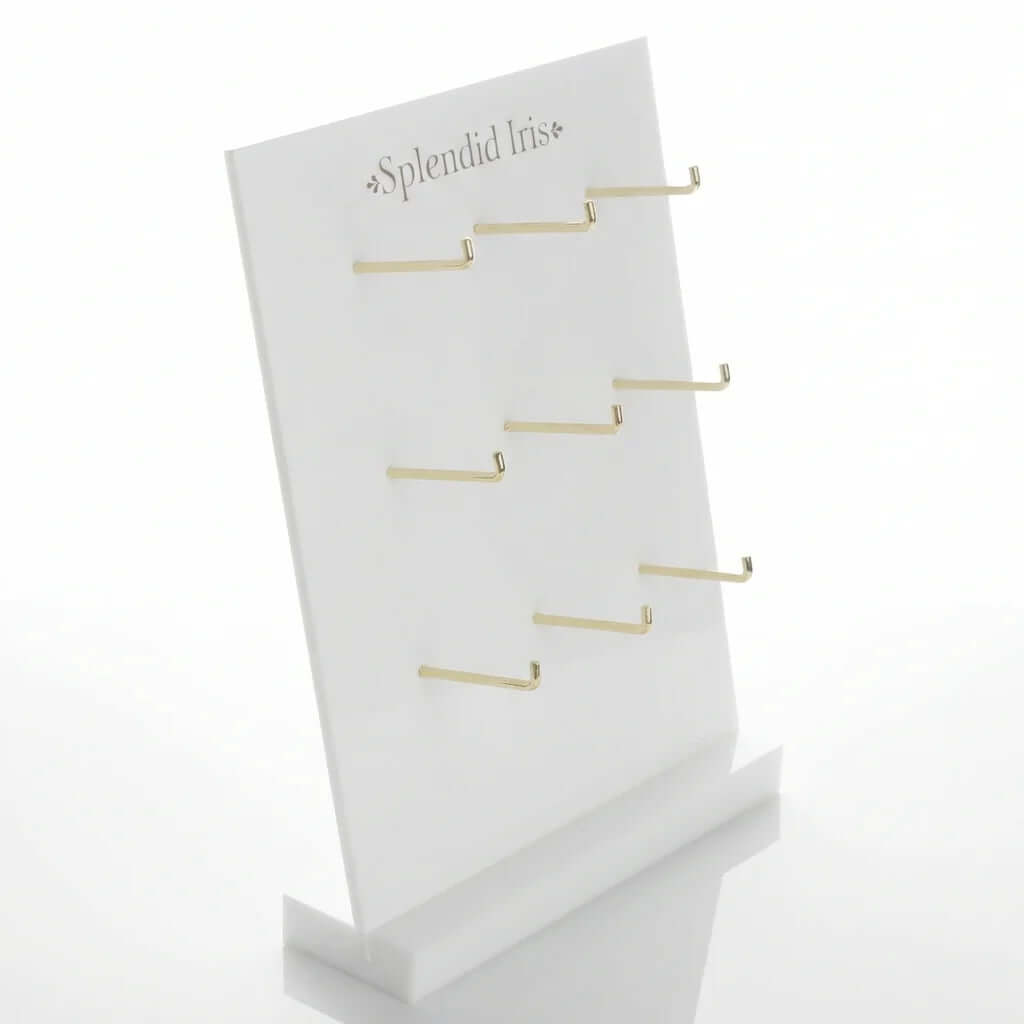 White acrylic leaning jewelry display stand with 9 gold hooks for hanging earring cards and necklaces